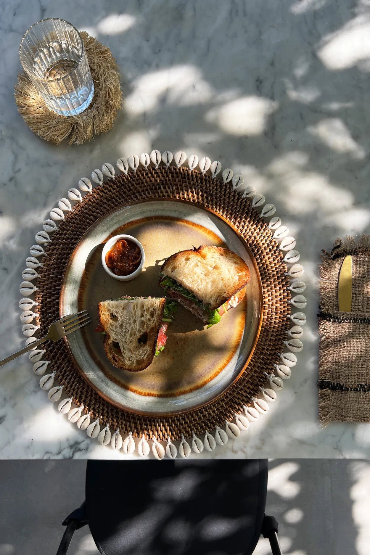 Set de table rond en rotin marron avec bordure de coquillages cauris
