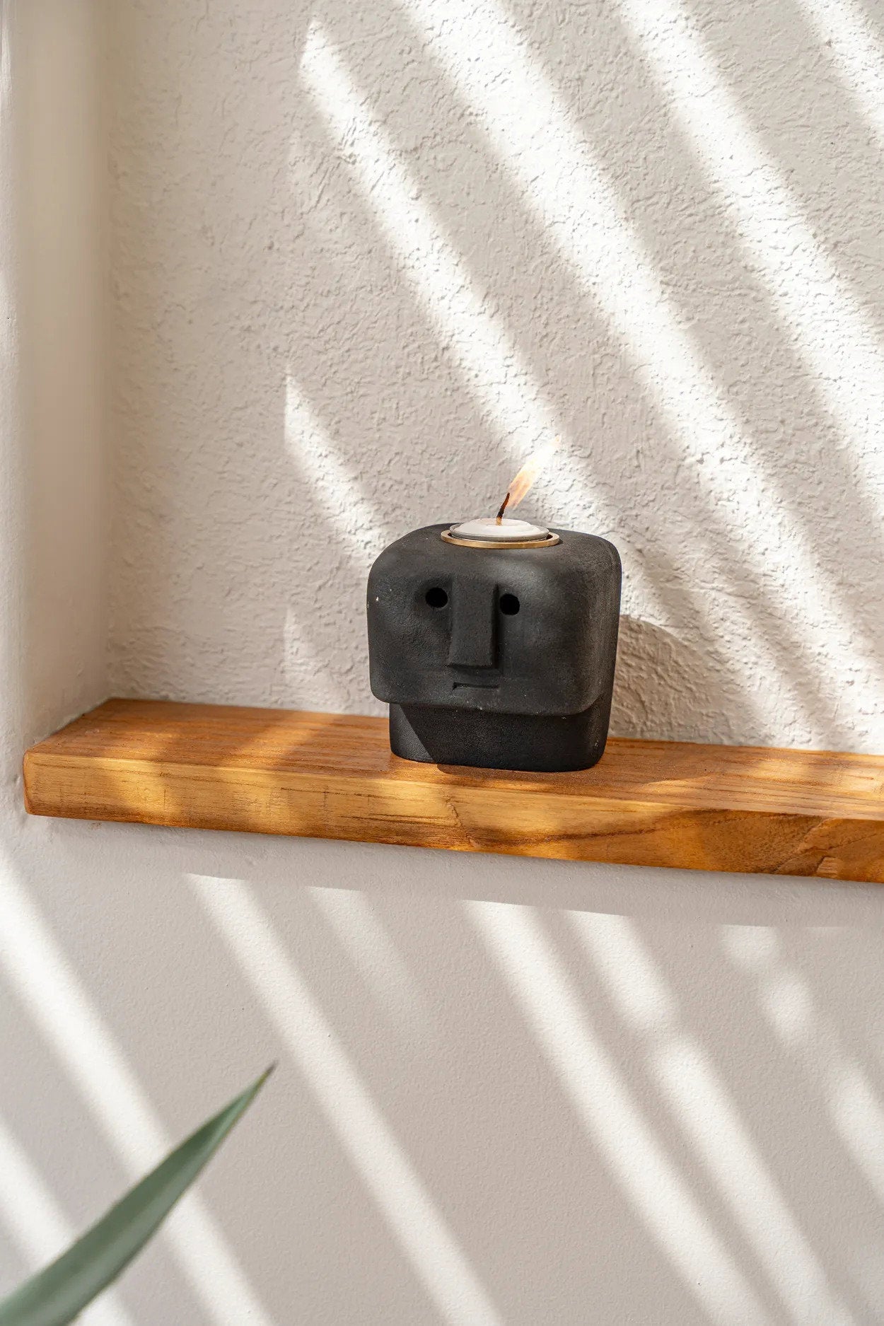 Porte-bougie totem en grès noir sculpté avec motifs géométriques