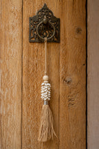 Pompon mural artisanal en coquillages cauris et raphia naturel