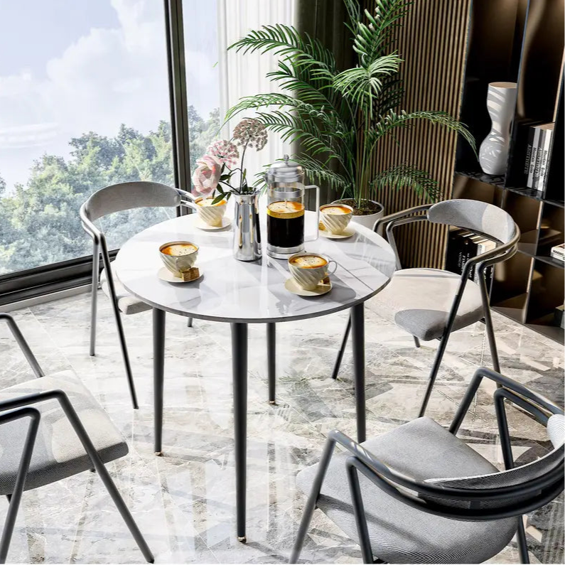 Table ronde effet marbre avec des chaises design dans une salle à manger chaleureuse.