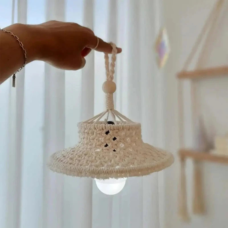 Abat-jour en macramé suspendu dans un salon, créant une ambiance chaleureuse et naturelle.