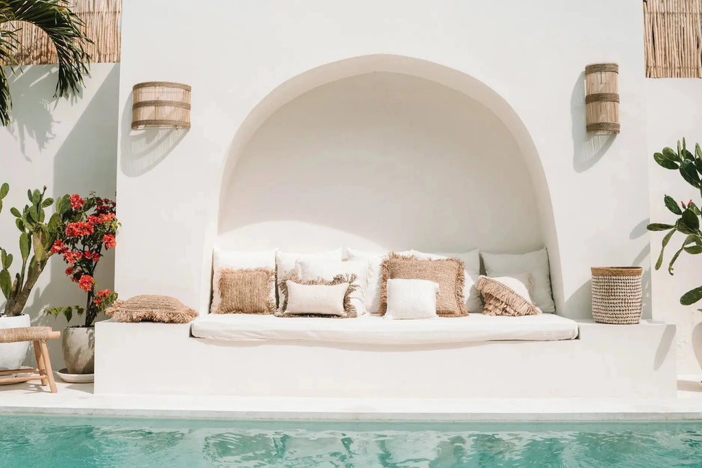 Coin salon extérieur avec coussins en fibres naturelles et coussin blanc