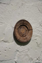 Assiette murale en rotin brun tressé avec motif en spirale au centre, diamètre 40 cm