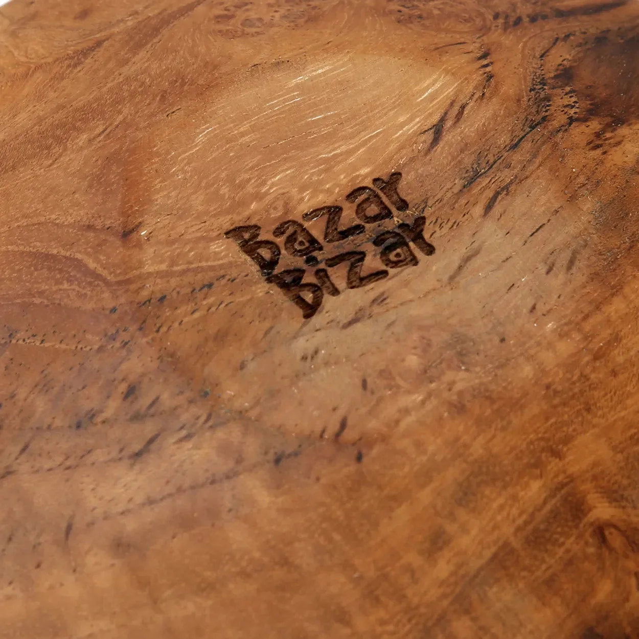 Assiette ronde en bois de teck naturel avec veinures apparentes sur surface en bois clair