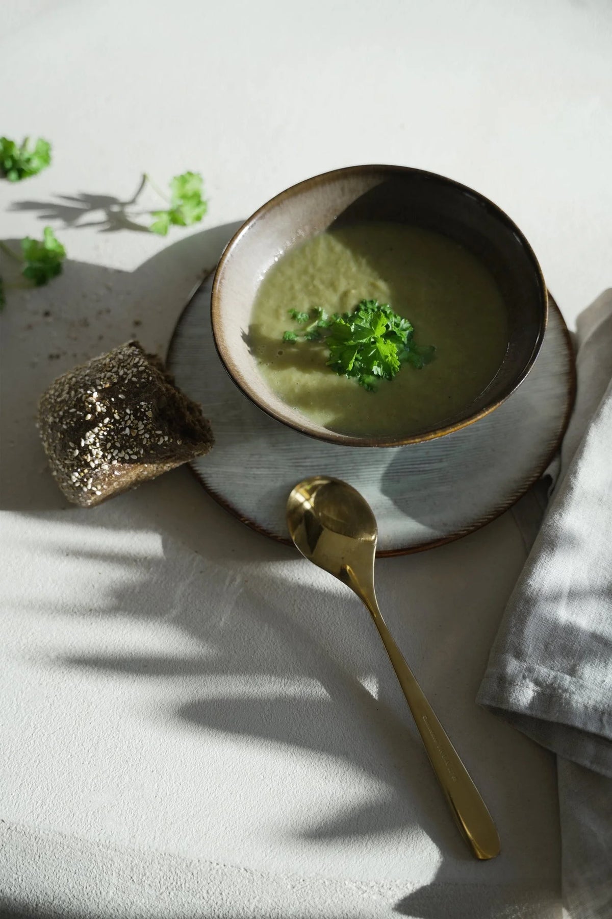 Bol en grès artisanal brun beige mat strié avec soupe verte au persil