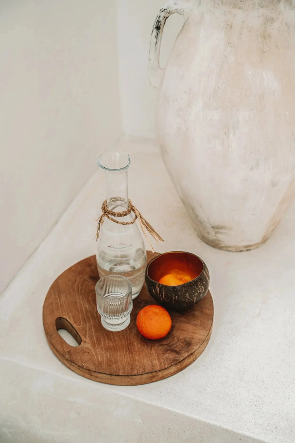 Plateau en noix de coco intérieur doré brillant avec bouteille d’eau, verre, noix de coco et orange