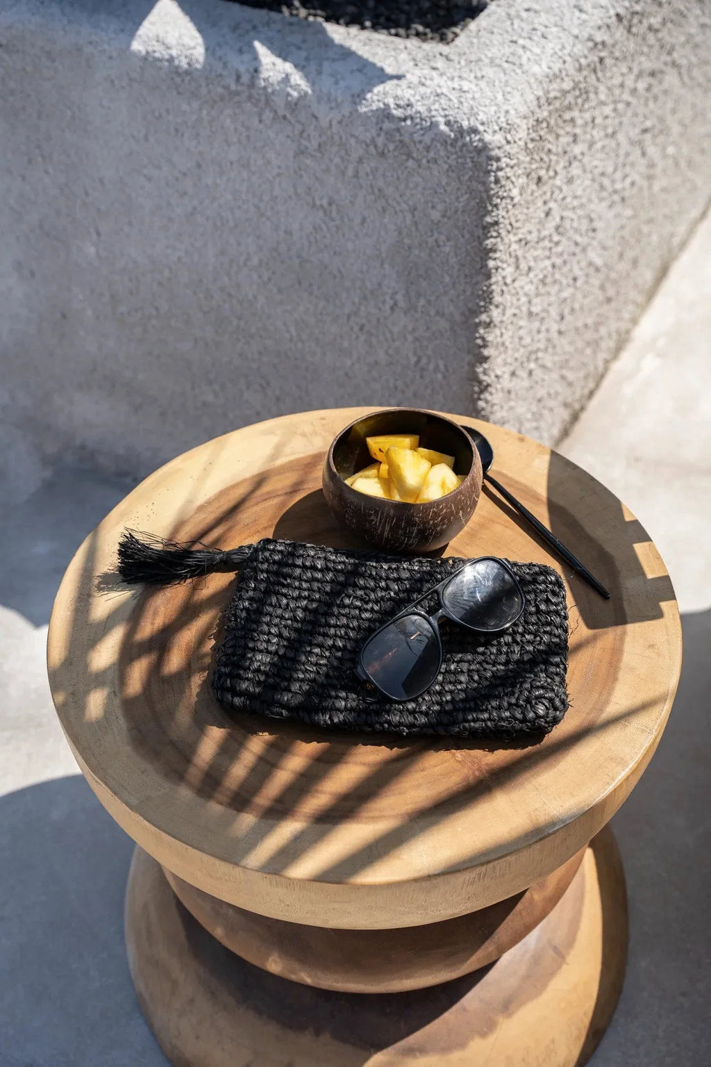 Sac pochette tissé noir avec lunettes de soleil foncées, style élégant et naturel