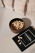 Bol en noix de coco naturelle brun foncé forme ronde rempli de pistachios