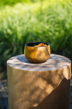 Bol en teck naturel de 12 cm avec intérieur foncé, rempli de bouchées marron clair