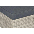 Tabouret en résine tressée grise avec coussin bleu foncé