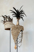 Chapeau décoratif en coquillages et plumes sur socle noir naturel