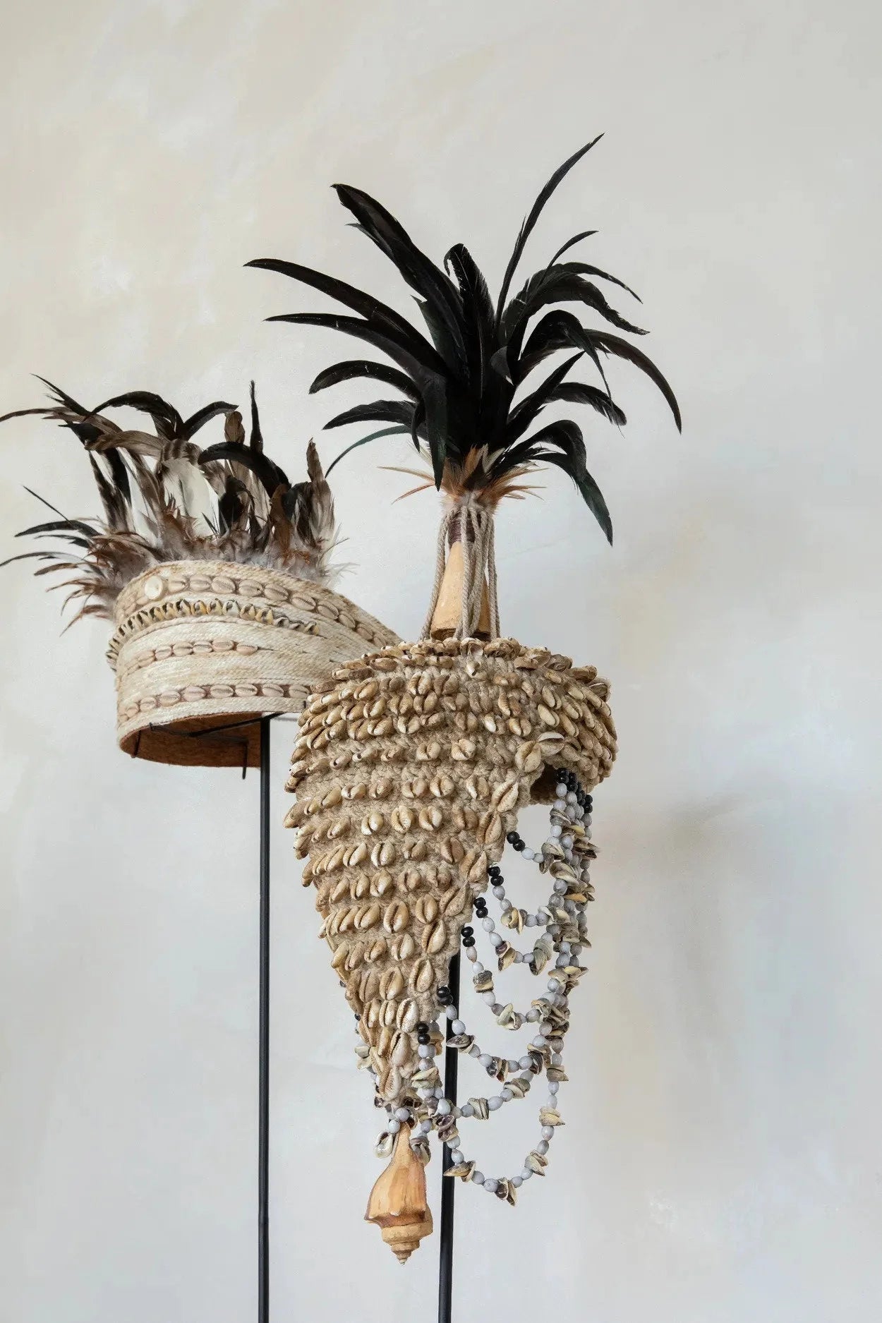 Chapeau décoratif en coquillages et plumes sur socle noir naturel