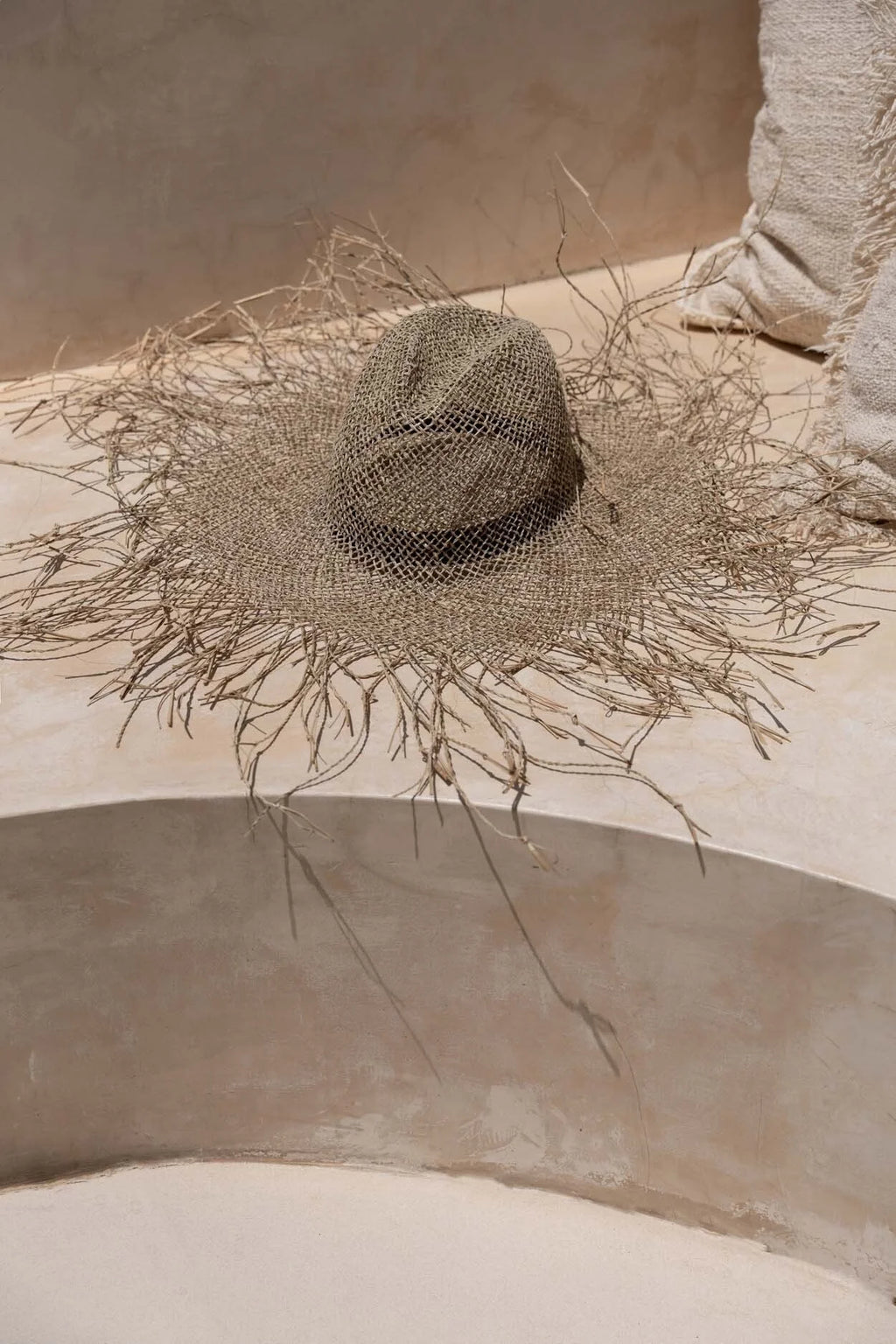 Chapeau de plage naturel en herbe marine texturé, large bord orné de brins délicats