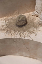Chapeau de plage naturel en herbe marine texturé, large bord orné de brins délicats