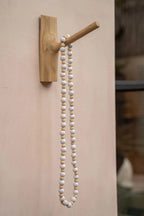 Porte-collier en bois naturel avec perles blanches