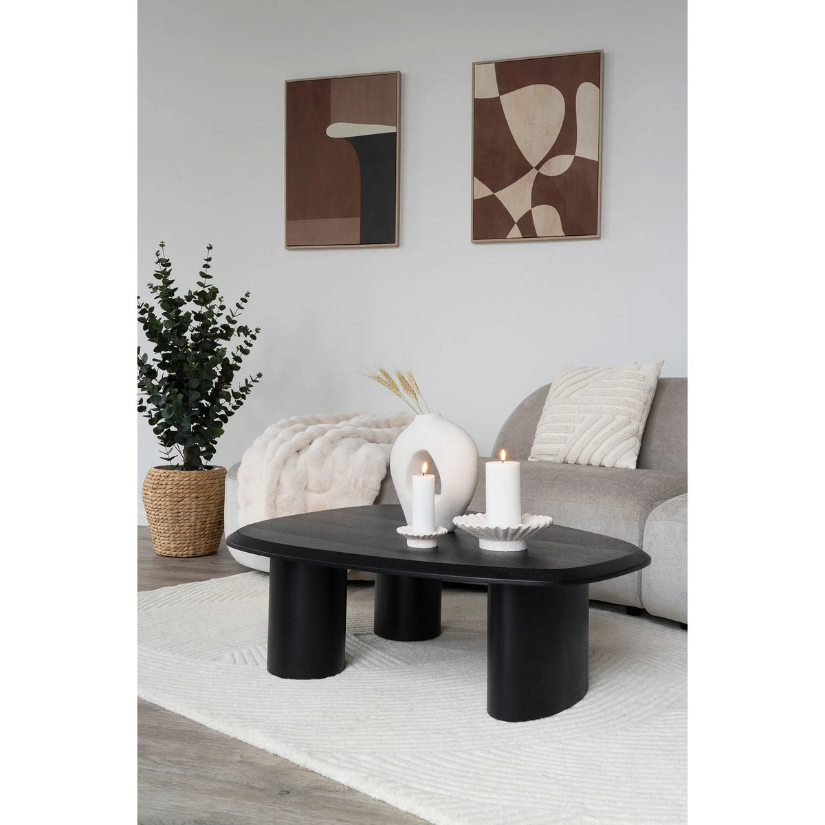 Table basse ovale noire à pieds cylindriques, coussin écru en coton géométrique tufté