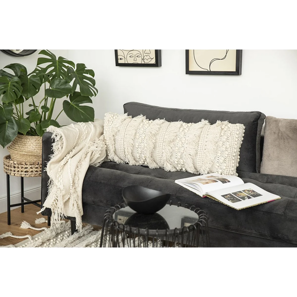 Canapé en velours gris foncé avec coussin écru à franges et motif tufté 35x95 cm