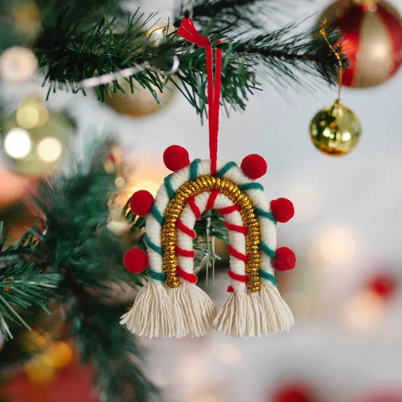 Décoration de Noël arche bohème en macramé rouge et blanc, un ornement chic avec des pompons rouges et dorés, idéal pour les fêtes de fin d'année.