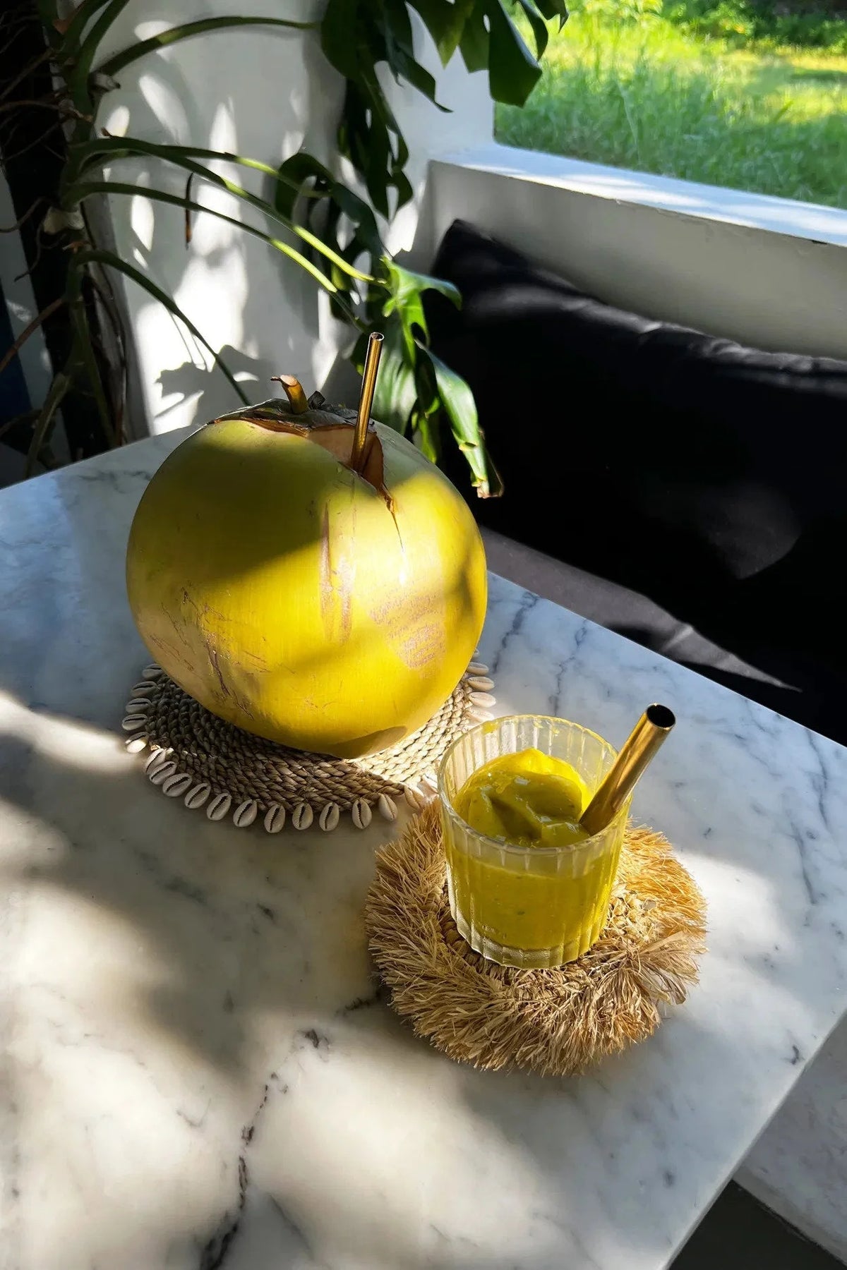 Coconut vert frais avec entaille et smoothie à la noix de coco dans un verre avec paille