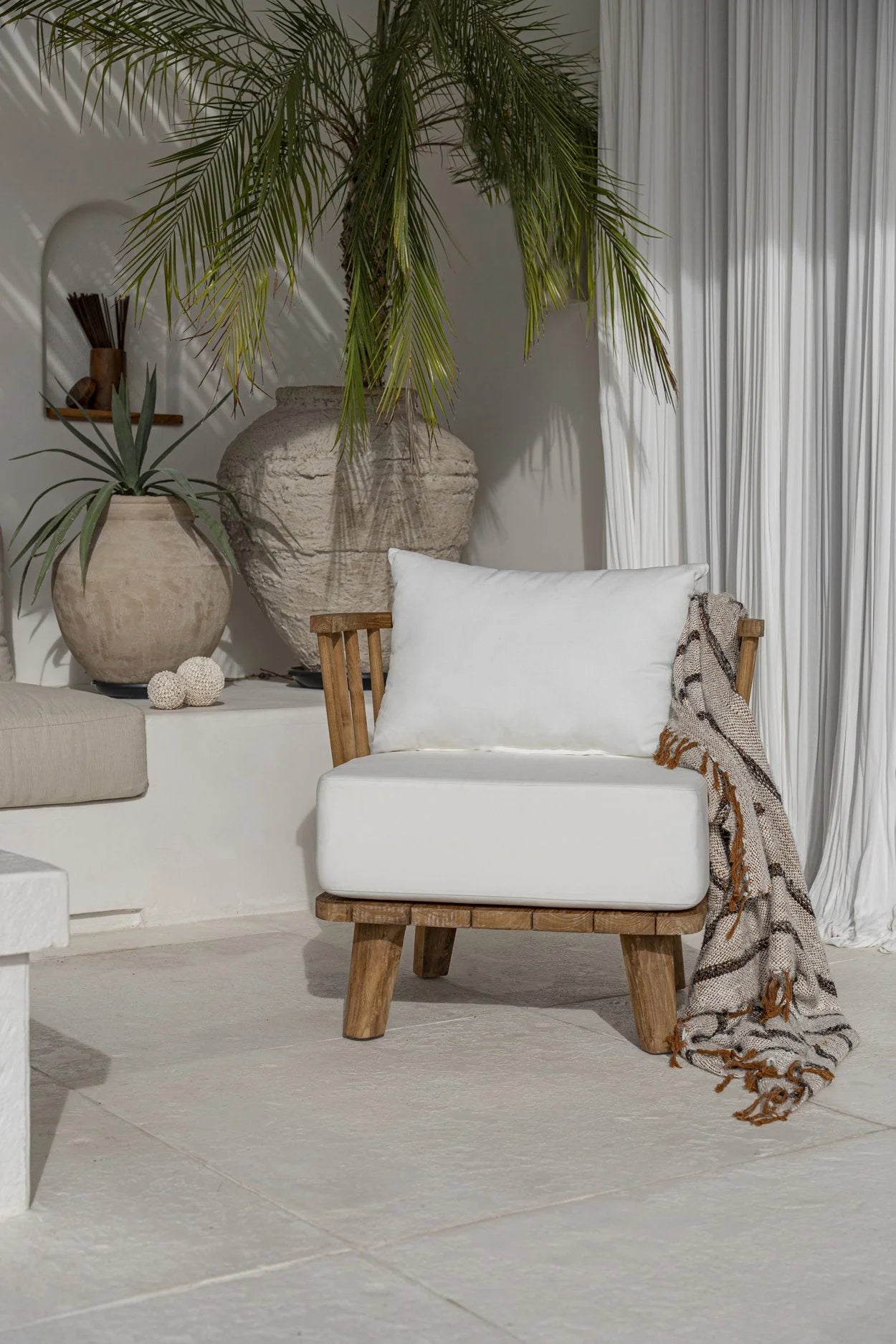 Fauteuil en teck recyclé avec coussins blancs et jeté rayé pour salon ou terrasse
