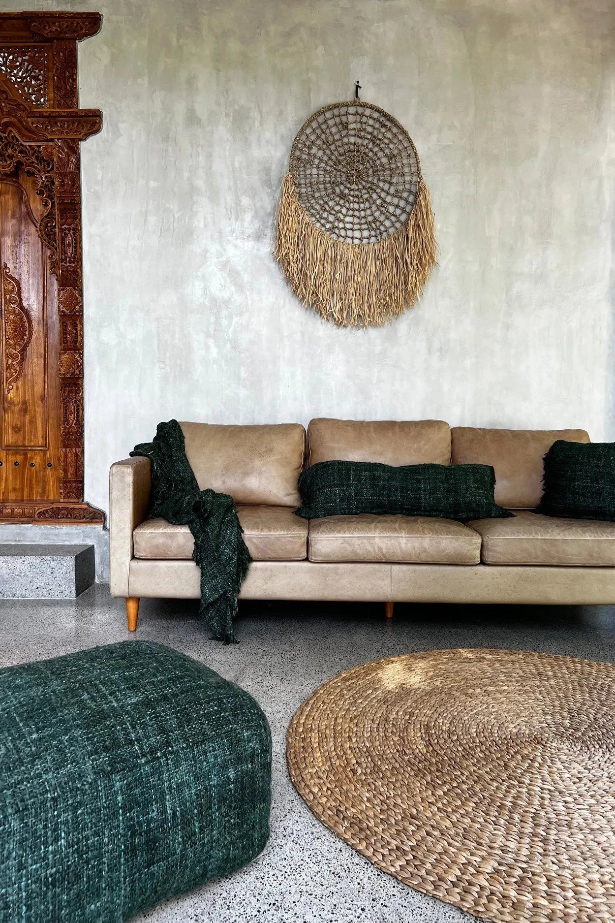 Canapé en cuir tan avec coussins verts foncés et couverture assortie pour décoration intérieure