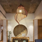 Grand lustre bambou suspendu dans un intérieur moderne avec un éclairage chaleureux.