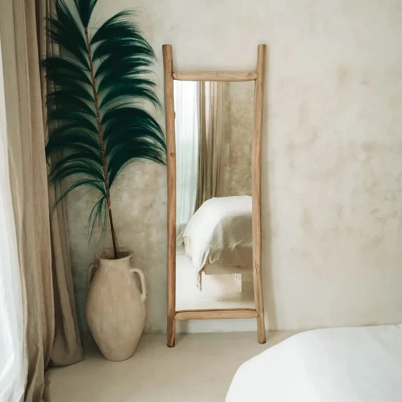 Grand miroir en teck dans une chambre à la décoration bohème avec des tons naturels
