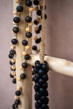Guirlande murale en perles de bois noir mat et naturel avec accents bois et suspension corde dorée