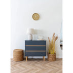 Commode bleu marine avec accents bois clair et pieds fuselés