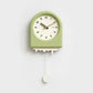 Horloge à pendule moderne verte avec un effet fonte et un pendule décoratif en forme de goutte suspendue.