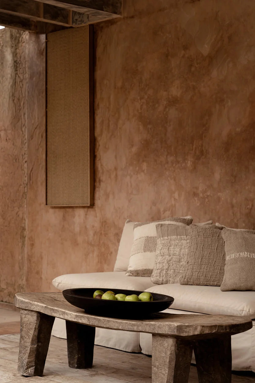 Table basse rustique en bois sombre taché, pieds texturés épais, surface patinée