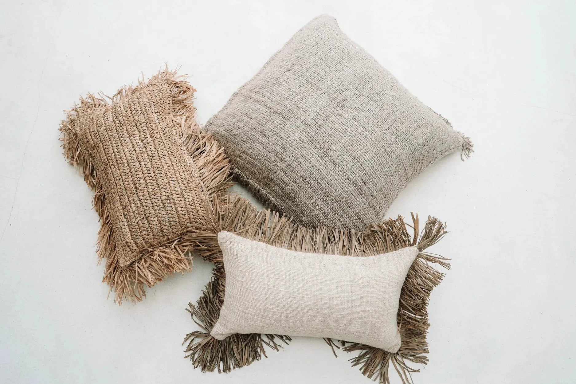 Trois coussins carrés beige en coton texturé à franges, 40x40 cm