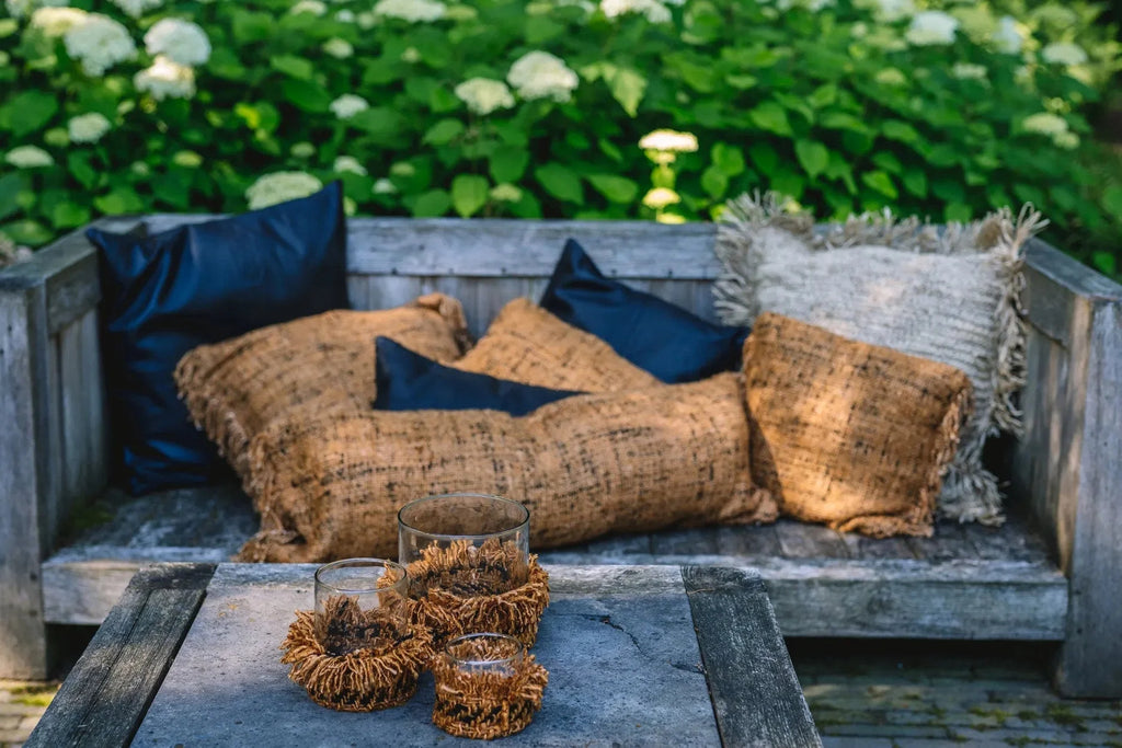 Housse de coussin en coton cannelle noir 35x100 cm sur un banc en bois avec coussins et bougies