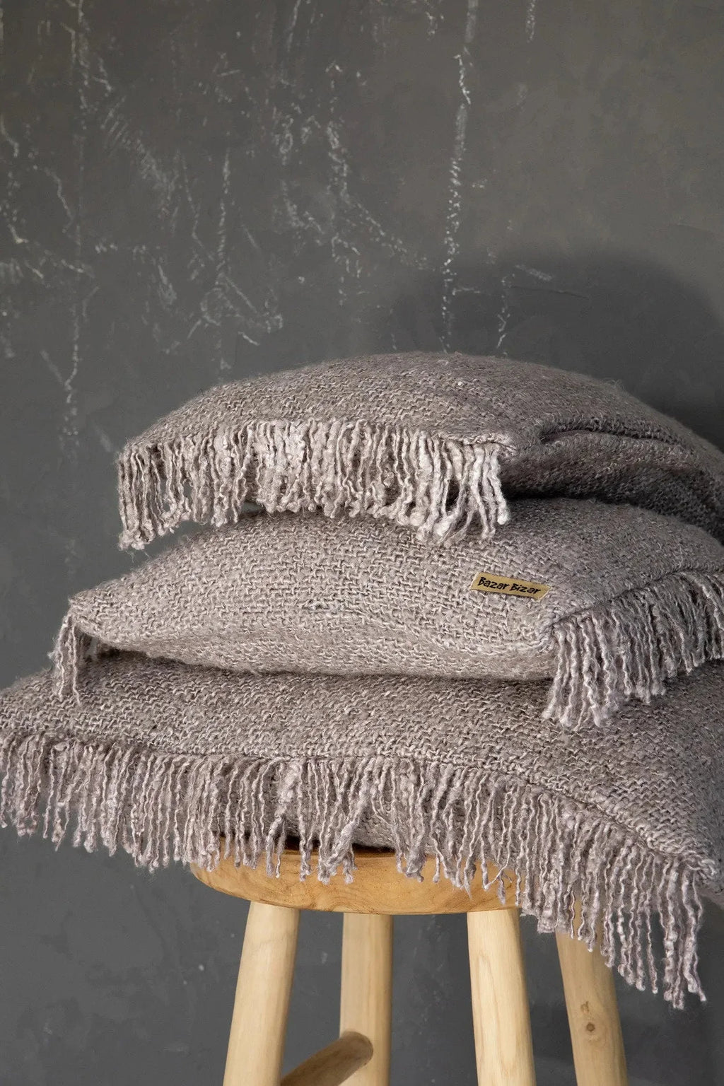 Pile de trois coussins en coton gris perle avec franges, 60x60 cm
