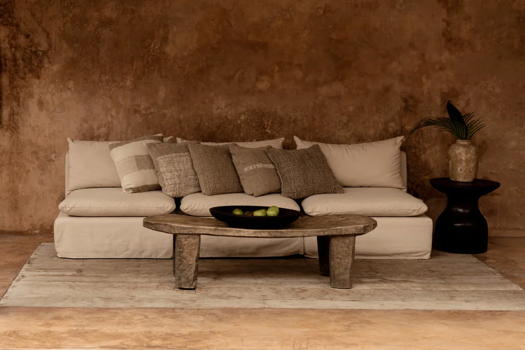 Canapé en lin beige avec coussins à carreaux relief et table basse rustique