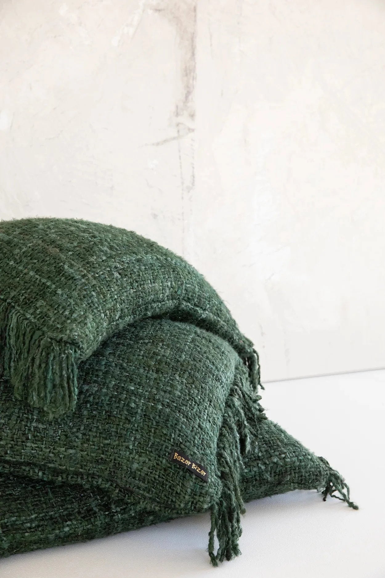 Coussin rectangulaire en coton vert foncé avec franges et texture douce