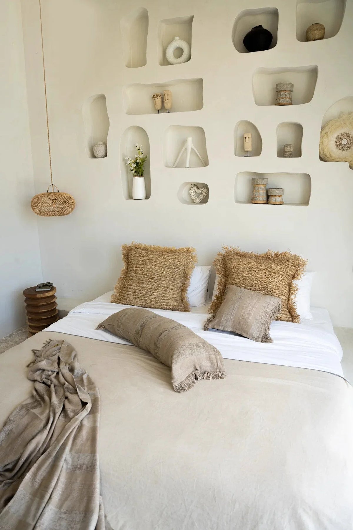 Housse de coussin velours béton 100x35 cm rectangulaire sur un lit cosy avec oreillers naturels