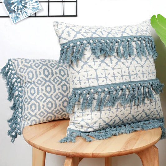 Housse de coussin bleu géométrique en situation sur un canapé avec motifs imprimés