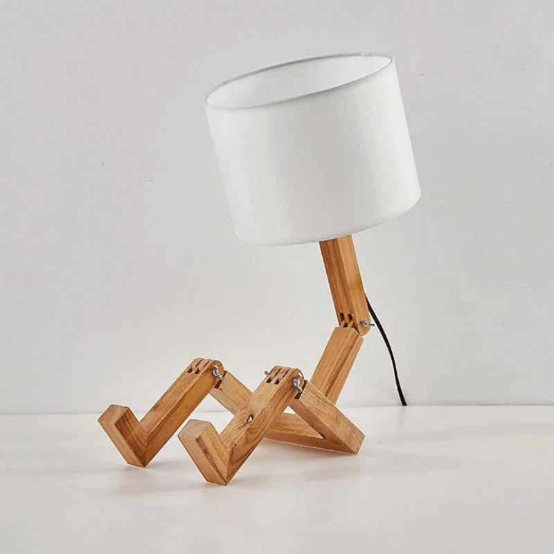 Vue de côté de la lampe de chevet bonhomme en bois avec abat-jour blanc