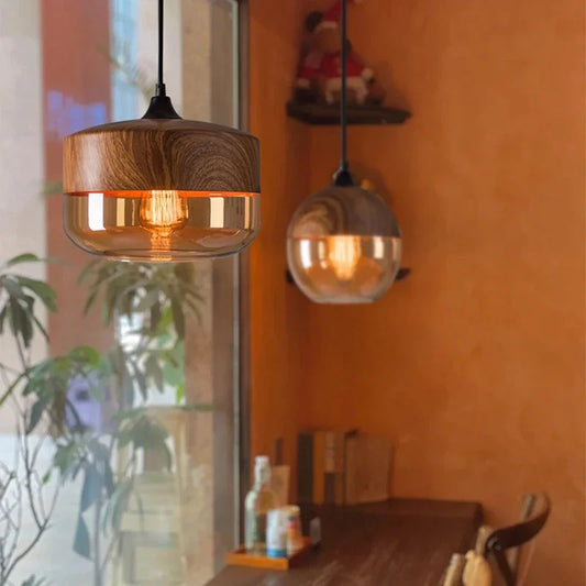 Lampe suspension bois et verre installée dans un café avec une lumière chaude.