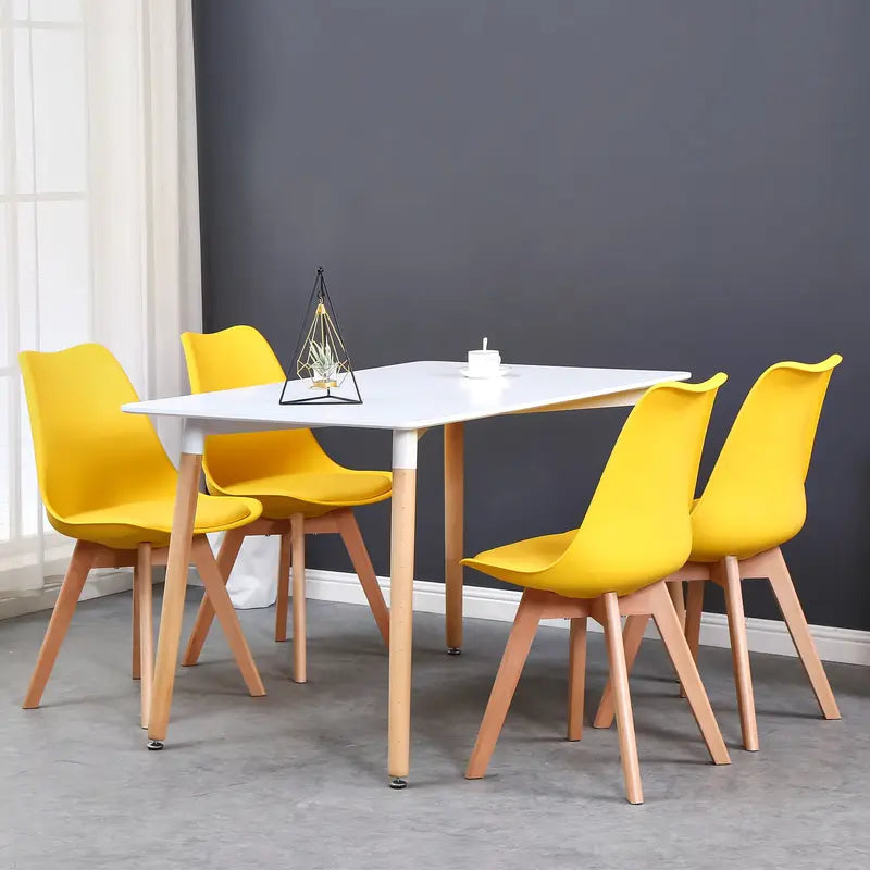 Lot de 6 chaises scandinaves jaunes autour d’une table blanche dans une salle à manger