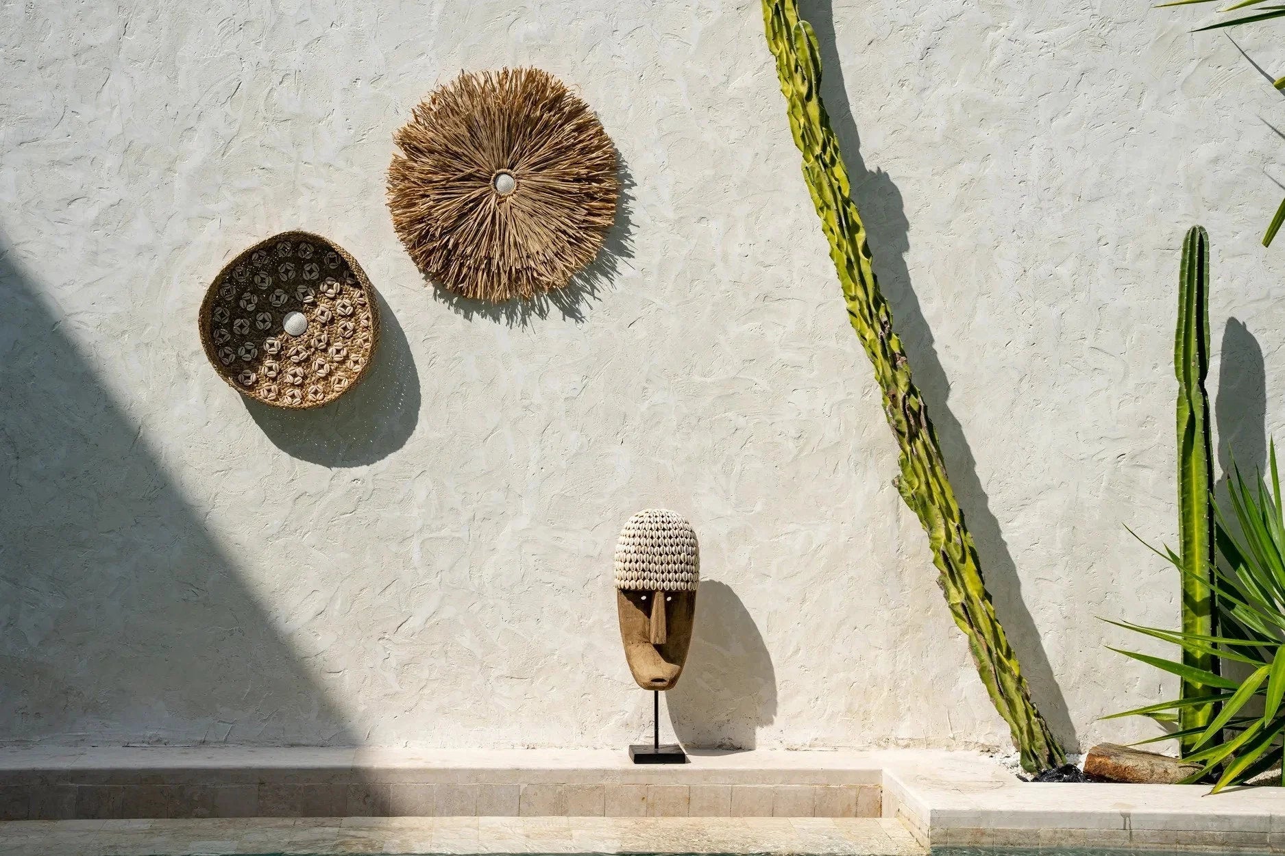 Masque décoratif tribal en bois et coquillages avec capuche tissée sur support 40 cm