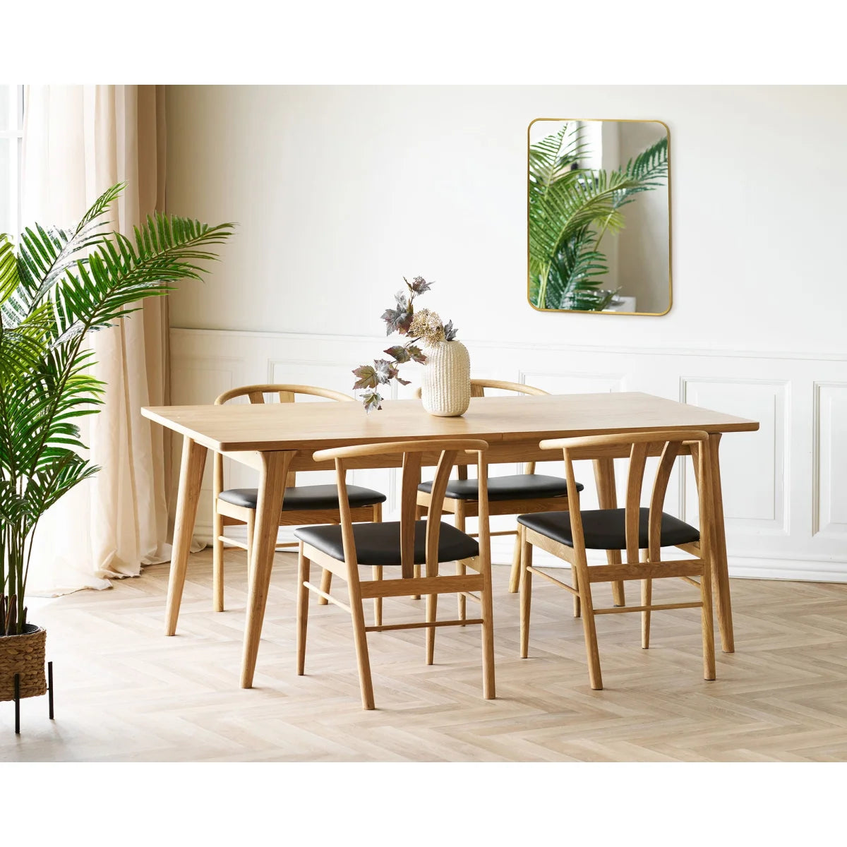 Table à manger en bois clair avec 4 chaises rembourrées noires et cadres courbés