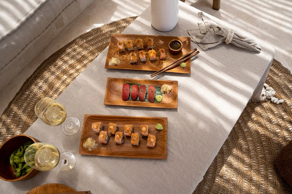 Platters en bois avec sushi, edamame et vin blanc sur nappe en lin beige