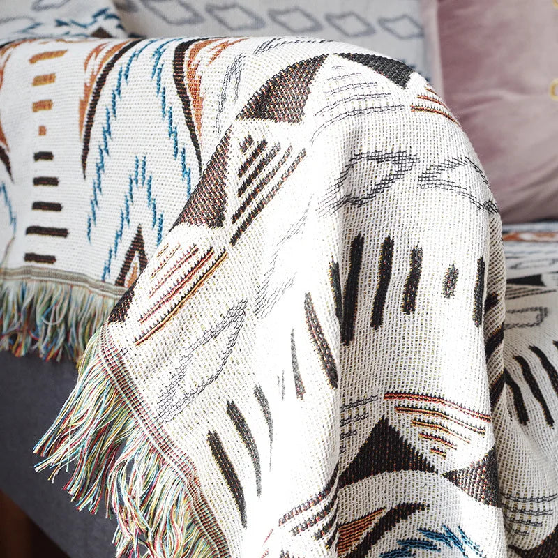 Gros plan sur les motifs géométriques du plaid aztèque à franges en coton