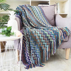 Couverture en zigzag coloré plaid chevron drapée sur un fauteuil gris pour moments cocooning