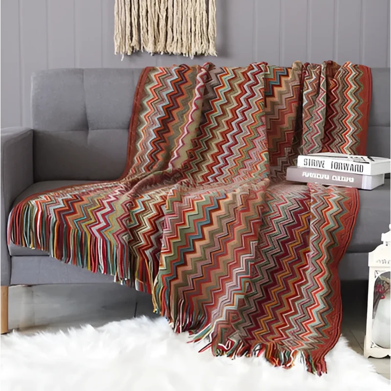 Couverture à motifs chevron colorés drapée sur un canapé gris pour des moments cocooning