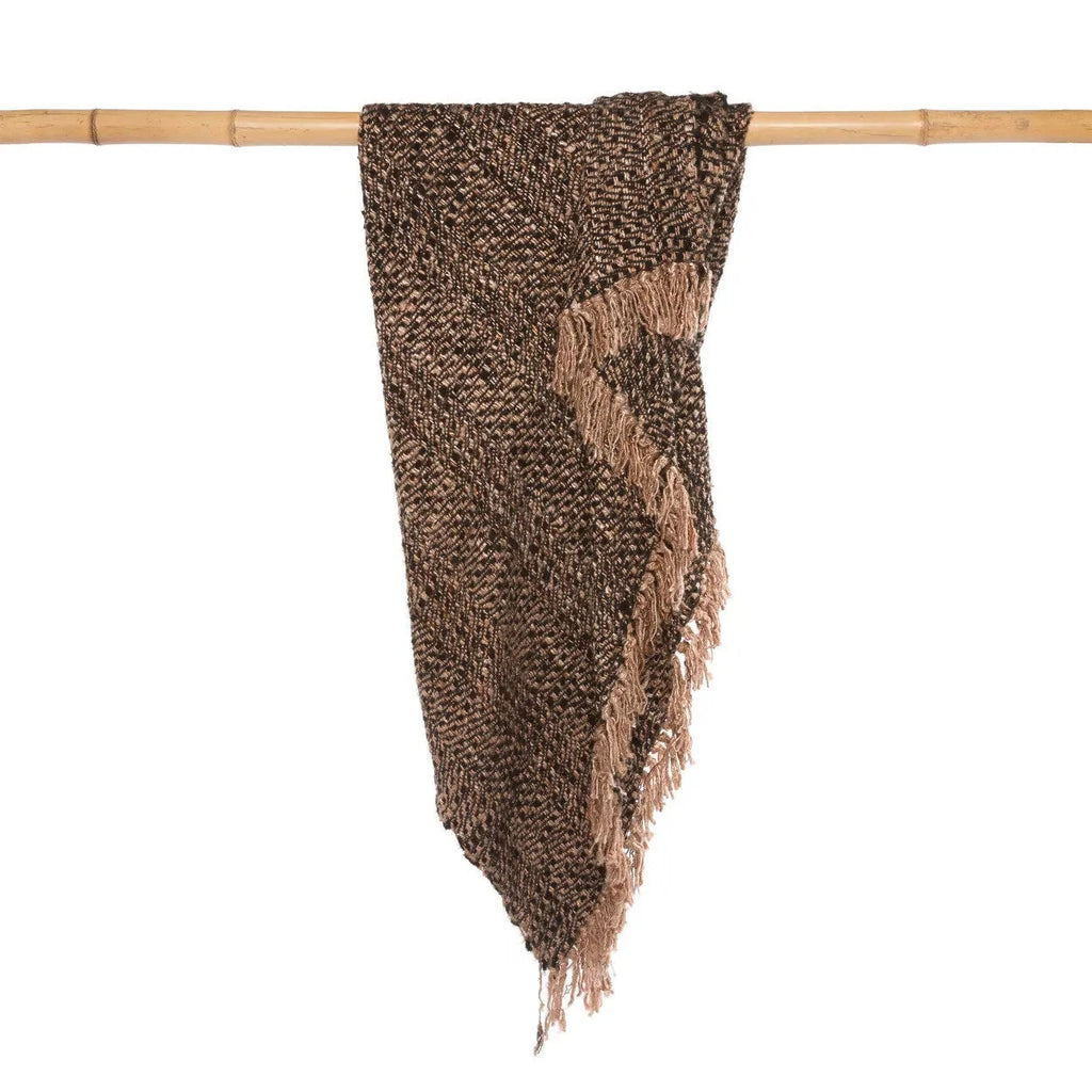 Plaid en coton tissé noir cuivre à franges chevrons sur une branche de bambou