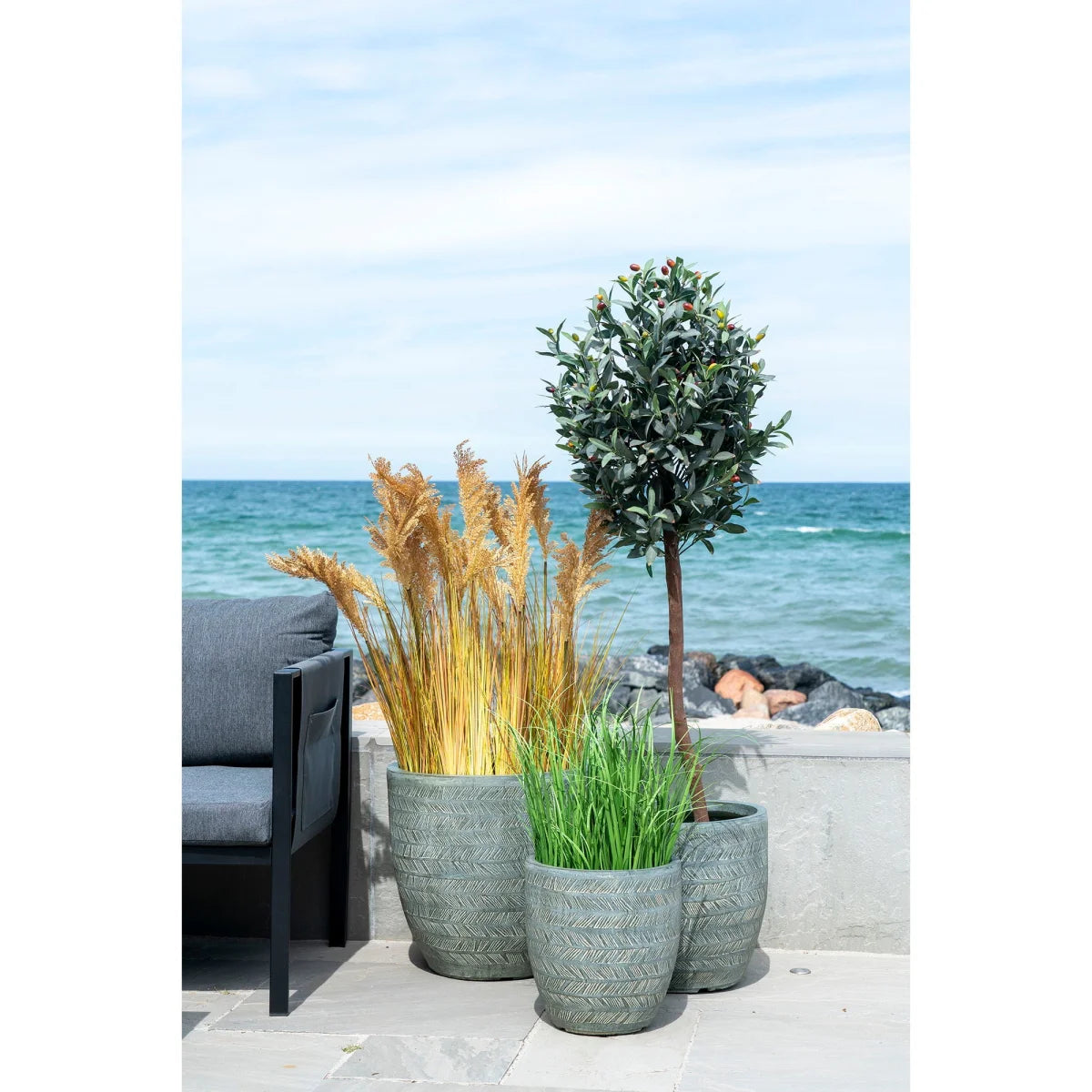 Trois pots gris texturés avec motifs géométriques, hauteurs variées