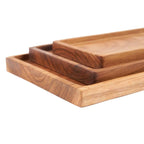 Ensemble de trois plateaux rectangulaires en teck naturel à grain visible, finition lisse et rebords arrondis
